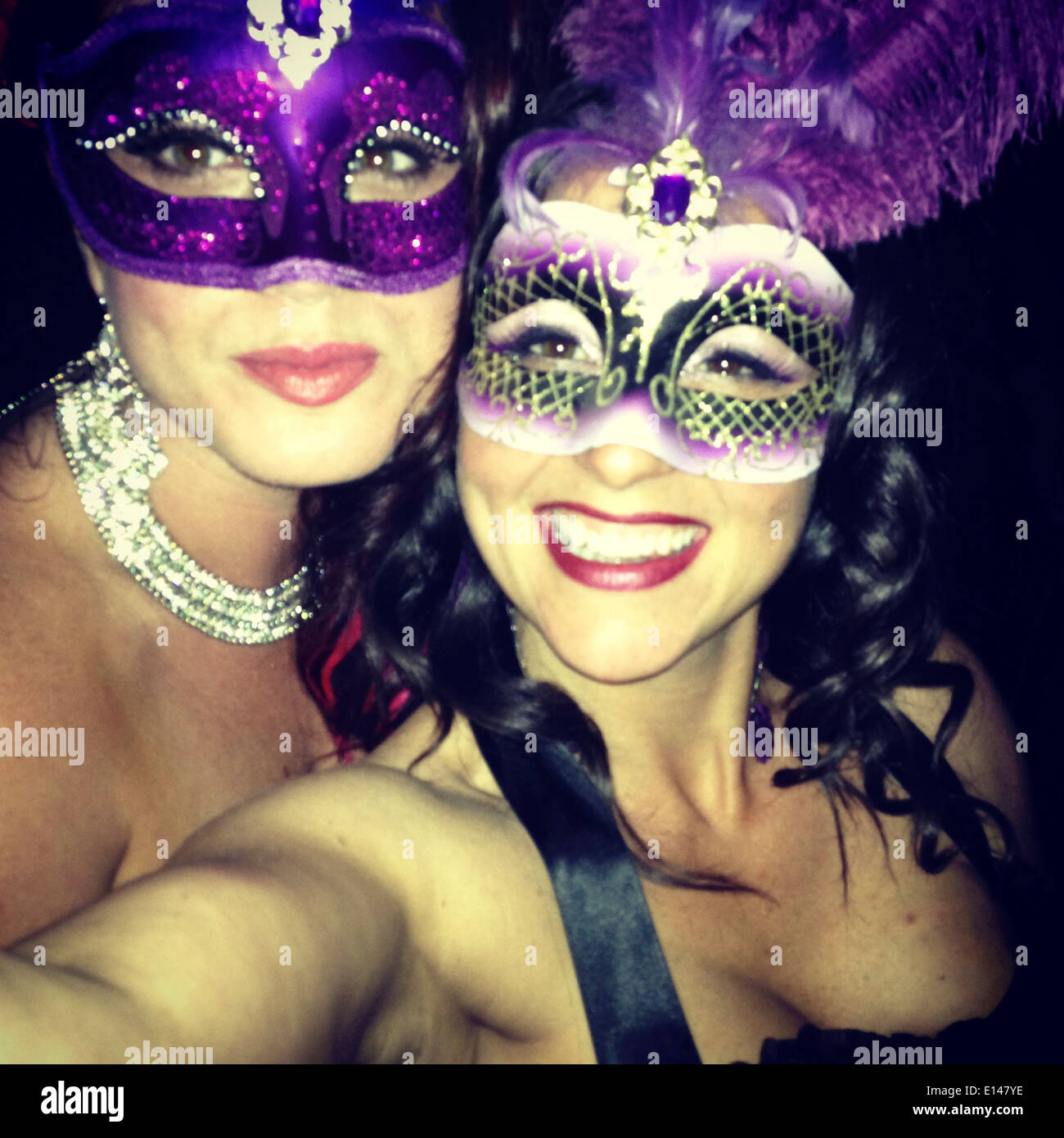 Caucasian women in masks taking pictures together - Smartphone Captured Stock Image