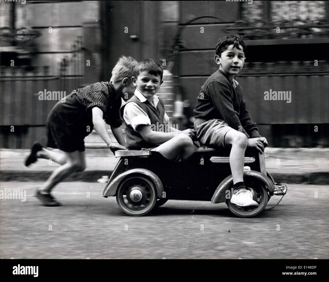 Apr. 17, 2012 - They Play In Safety: No license, no petrol, no danger! A half-man-power car speeds down a play street. They can Stock Photo