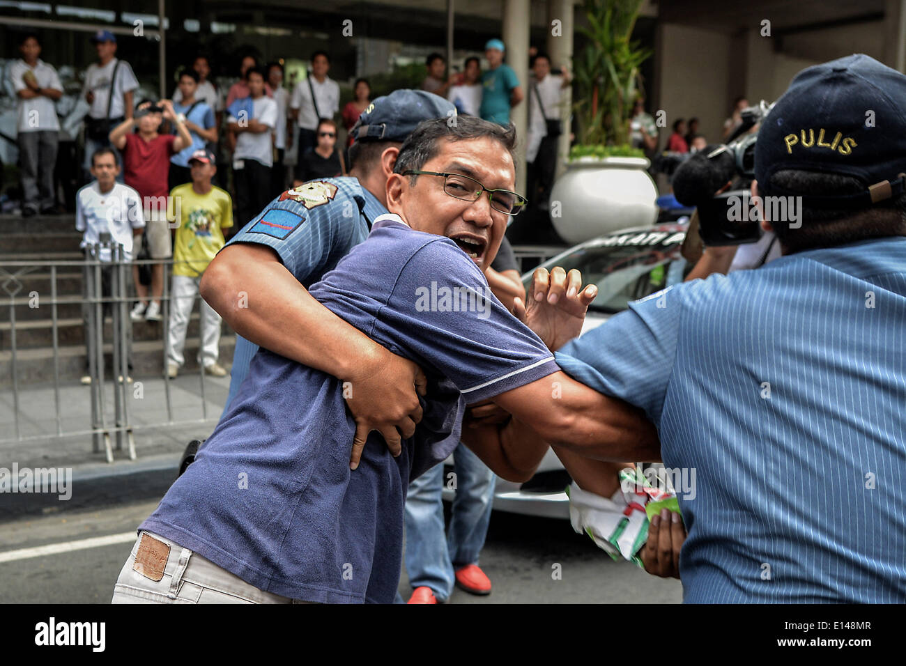 Makati, Philippines. 22nd May, 2014. Policemen attempt to arrest former congressman and activist Teddy Casino during a protest near the venue of the World Economic Forum on East Asia at the financial district of Makati, south of Manila, Philippines, May 22, 2014. Demonstrators criticized the Philippine government for allegedly hiding the worsening poverty and rampant corruption in the country as it welcomes foreign leaders and business heads during Asia's version of the World Economic Forum.Photo: Ezra Acayan/NurPhoto Credit:  Ezra Acayan/NurPhoto/ZUMAPRESS.com/Alamy Live News Stock Photo