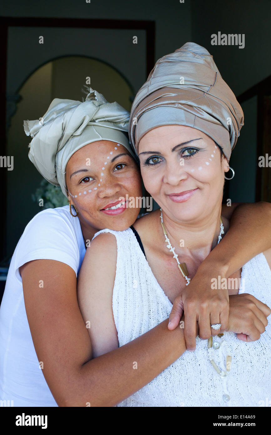 Mixed race women hugging Stock Photo - Alamy