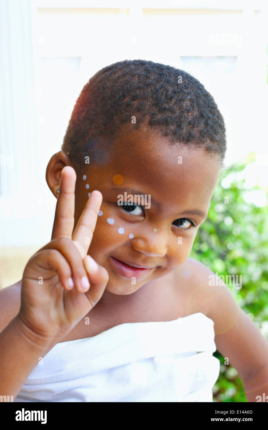 Mixed race girl giving peace sign Stock Photo