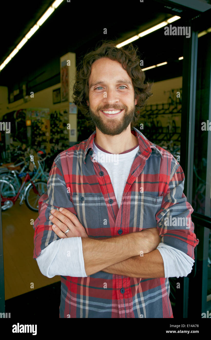 Caucasian man smiling in bicycle shop Stock Photo