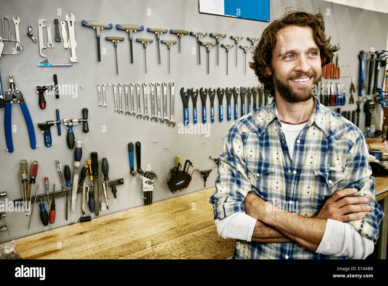 Caucasian man smiling in bicycle repair shop Stock Photo