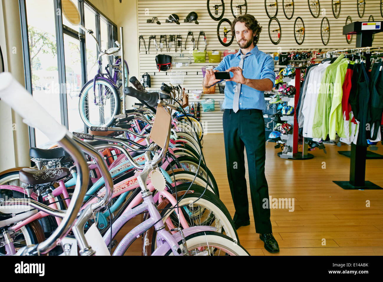 Caucasian businessman taking pictures in bicycle shop Stock Photo