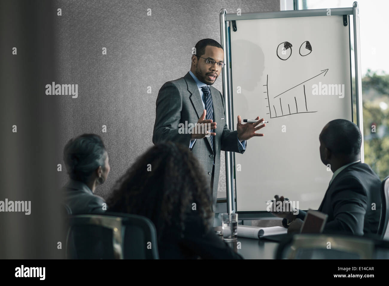 Businessman talking to colleagues in meeting Stock Photo