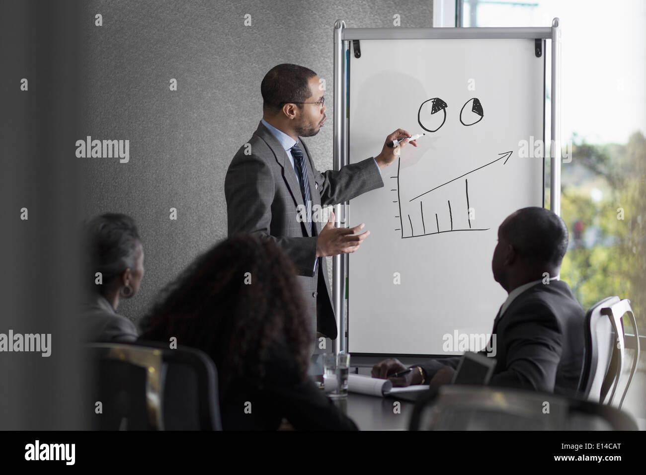 Businessman talking to colleagues in meeting Stock Photo