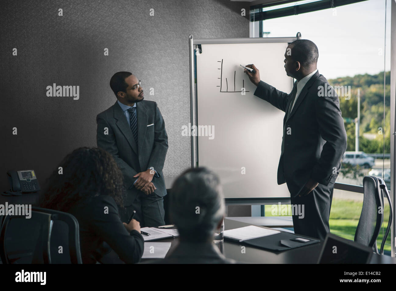 Businessman talking to colleagues in meeting Stock Photo