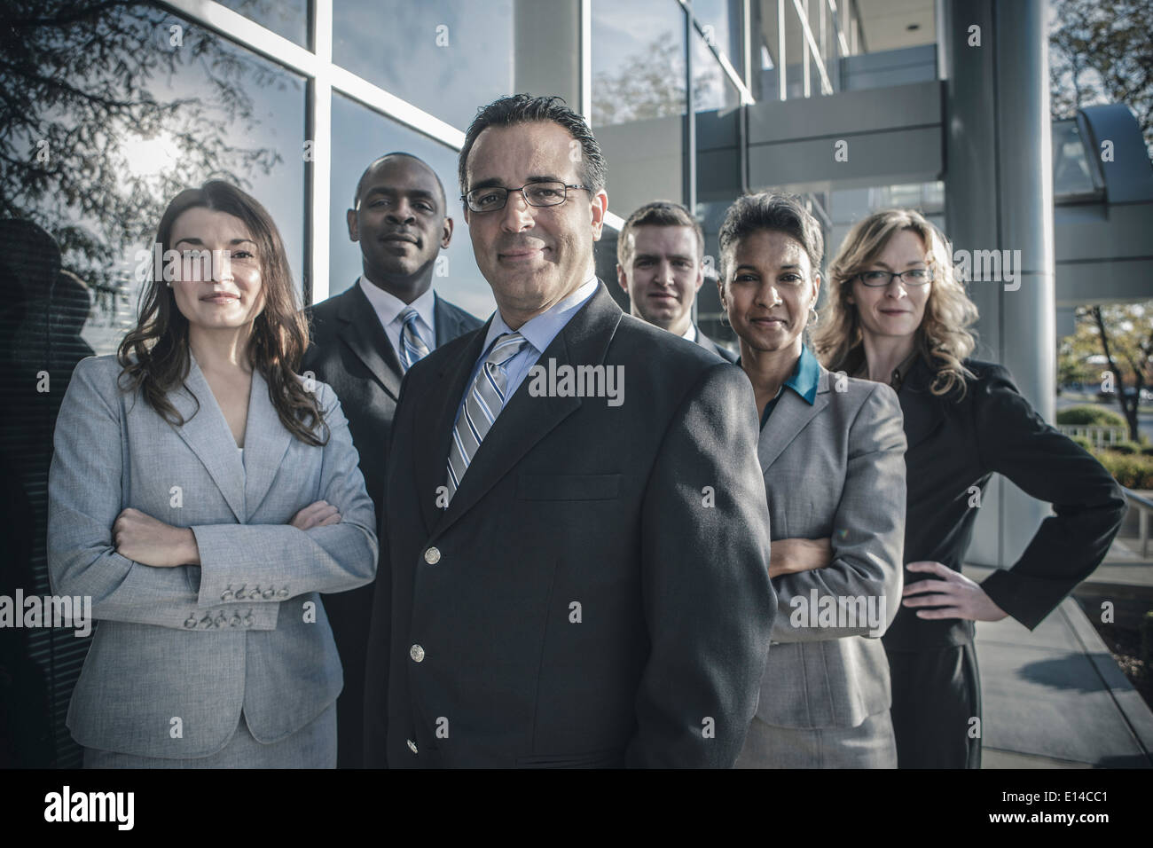 Business people smiling outside office building Stock Photo