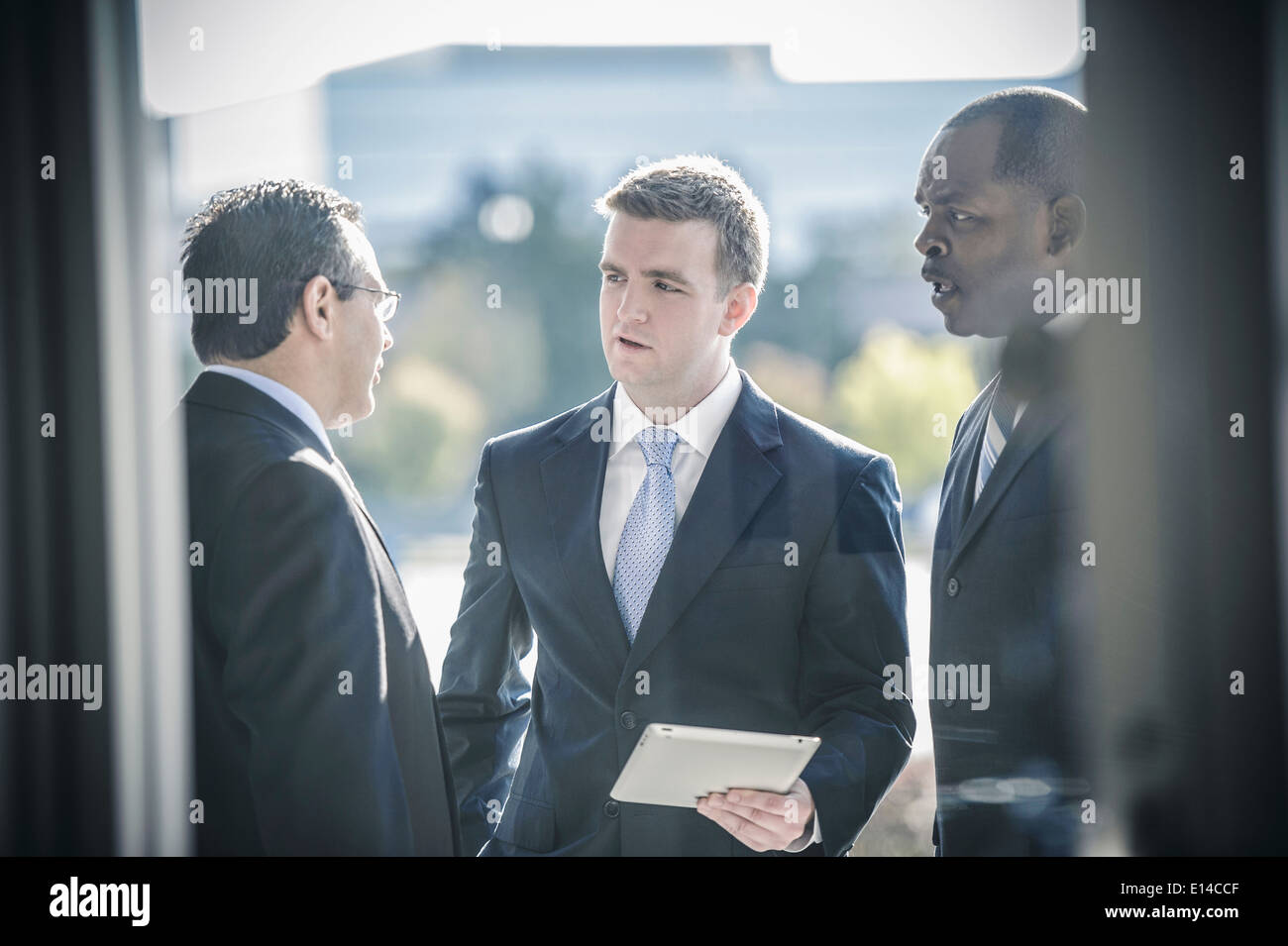 Businessmen using digital tablet outside office Stock Photo