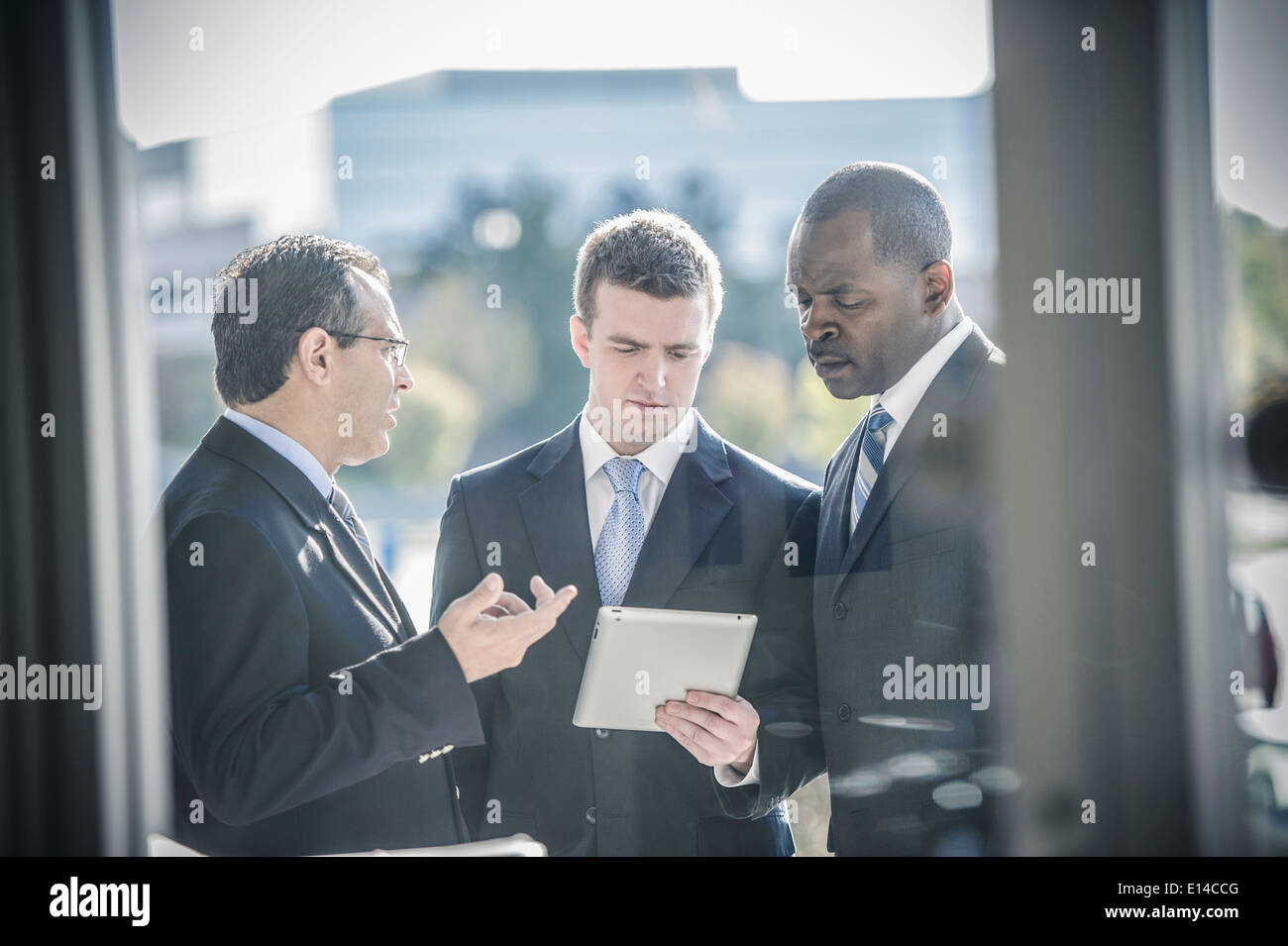 Businessmen using digital tablet outside office Stock Photo
