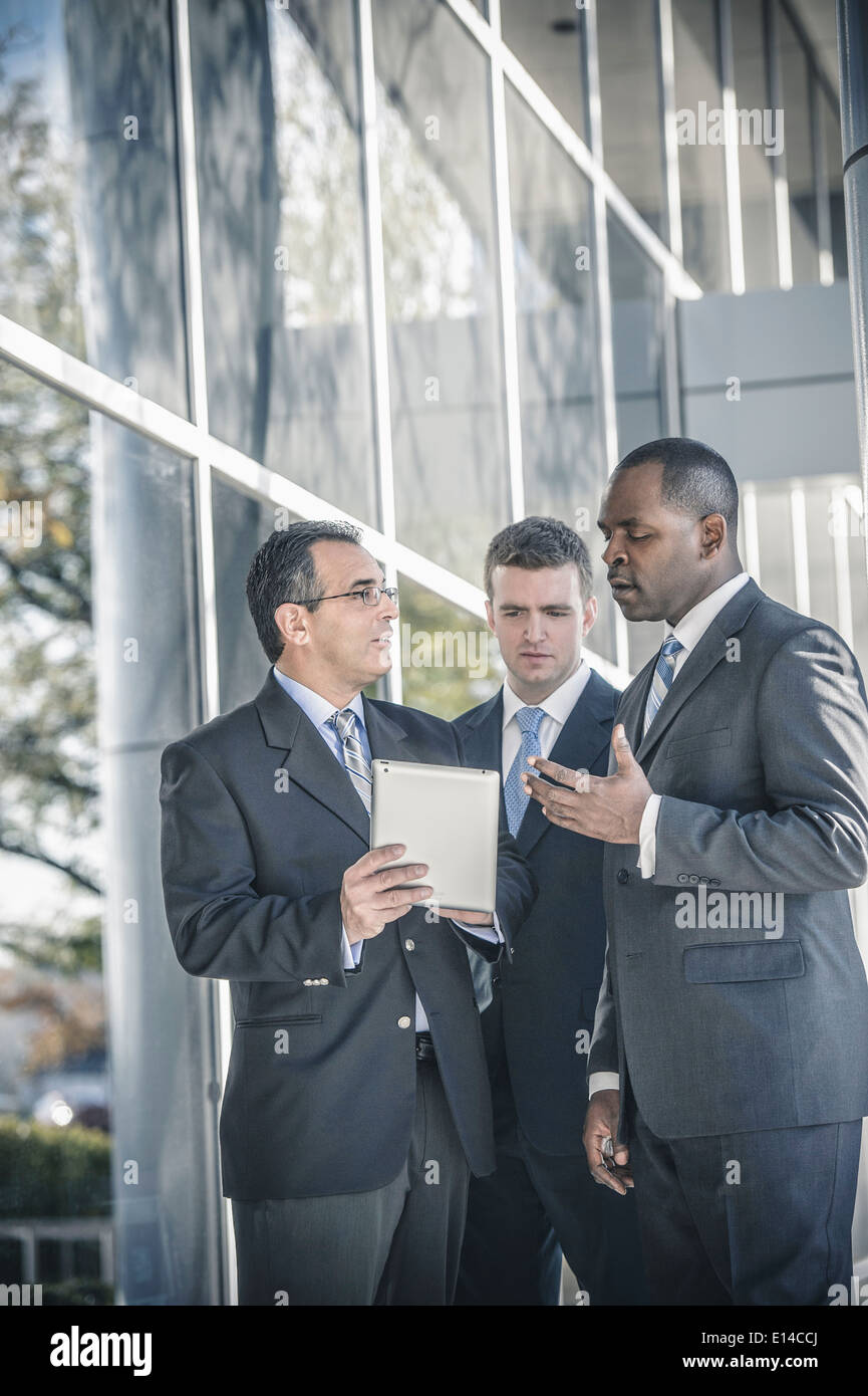 Businessmen using digital tablet outside office Stock Photo