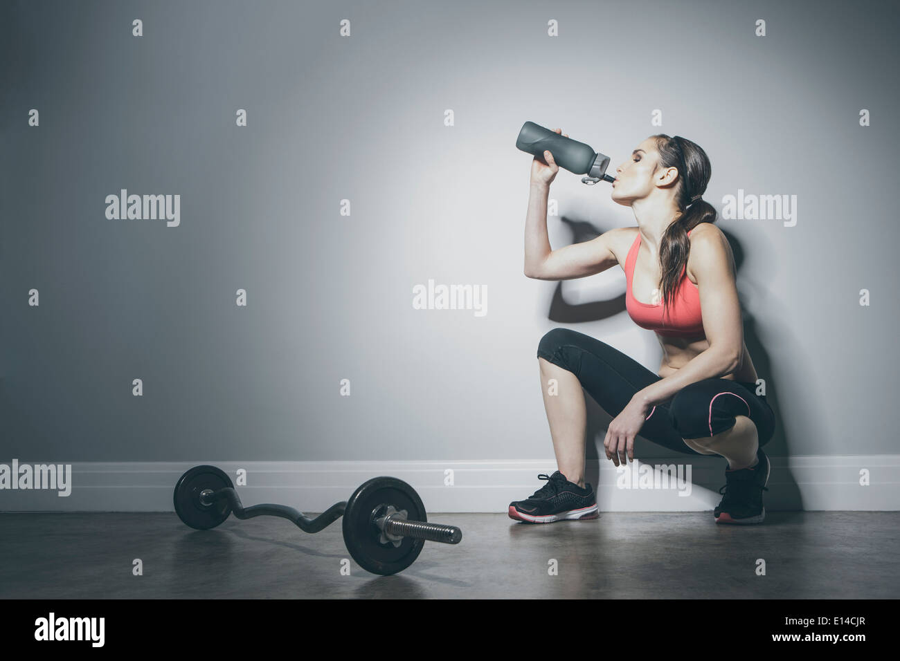 Caucasian woman in sportswear drinking from water bottle Stock Photo