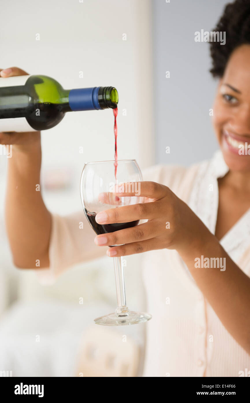 Black woman pouring glass of red wine Stock Photo - Alamy