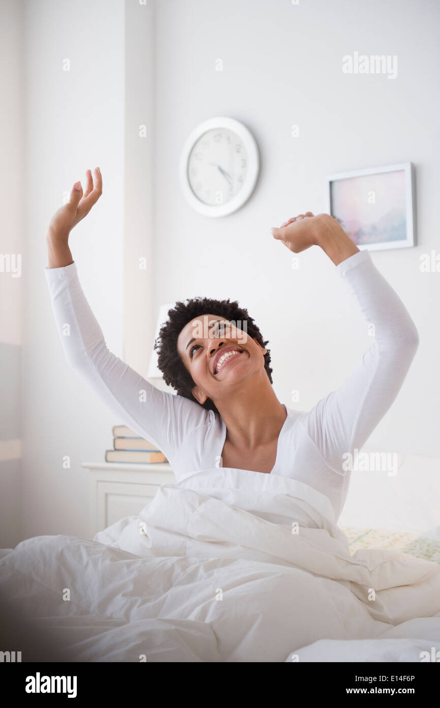 Happy Black woman awaking in bed Stock Photo