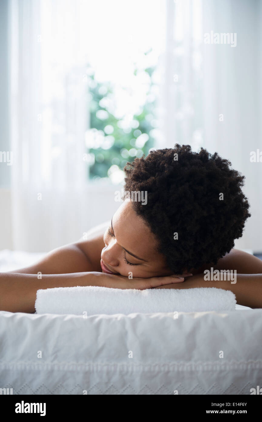Serene Black woman laying on massage table Stock Photo
