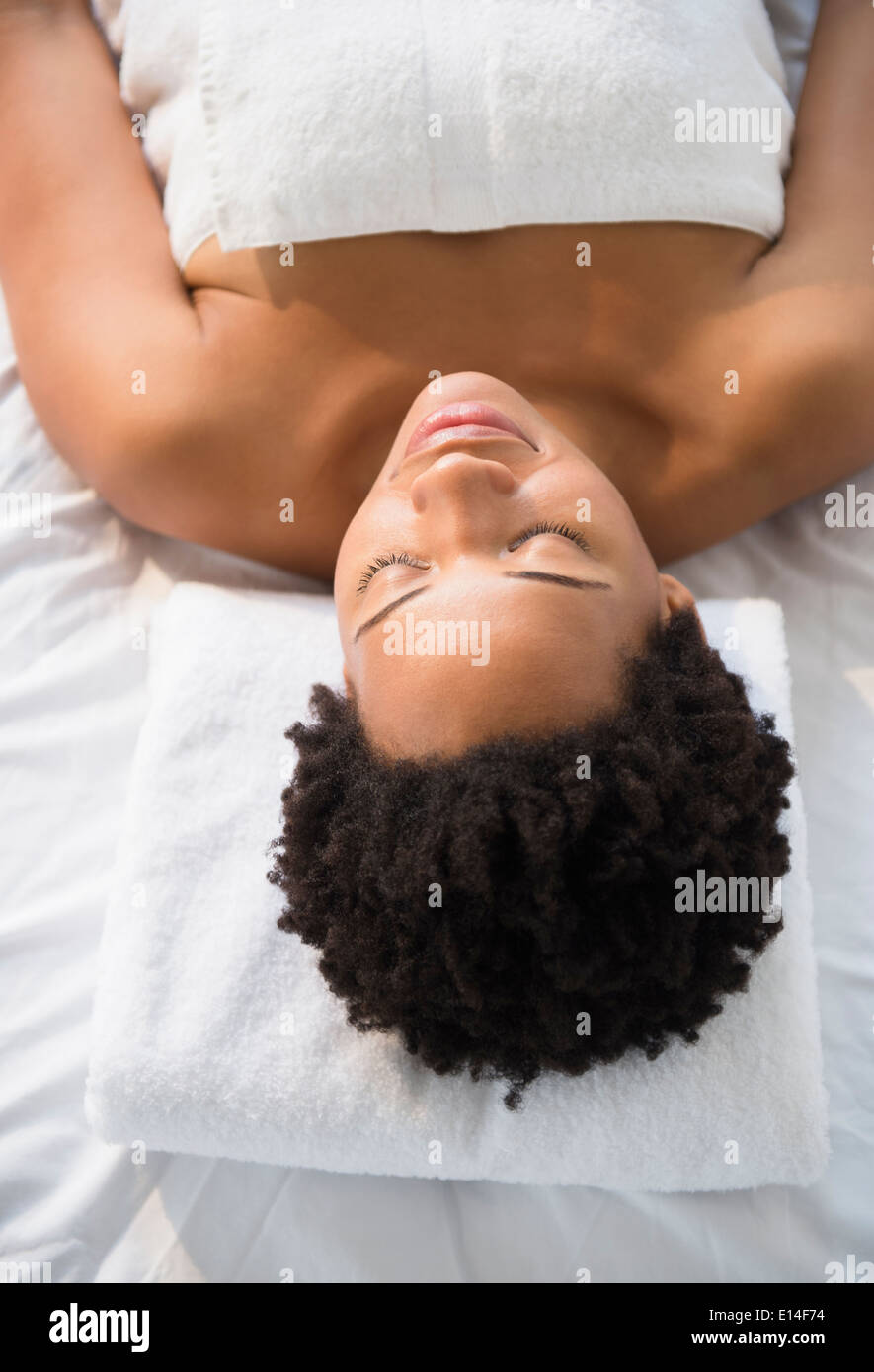 Serene Black woman laying on massage table Stock Photo