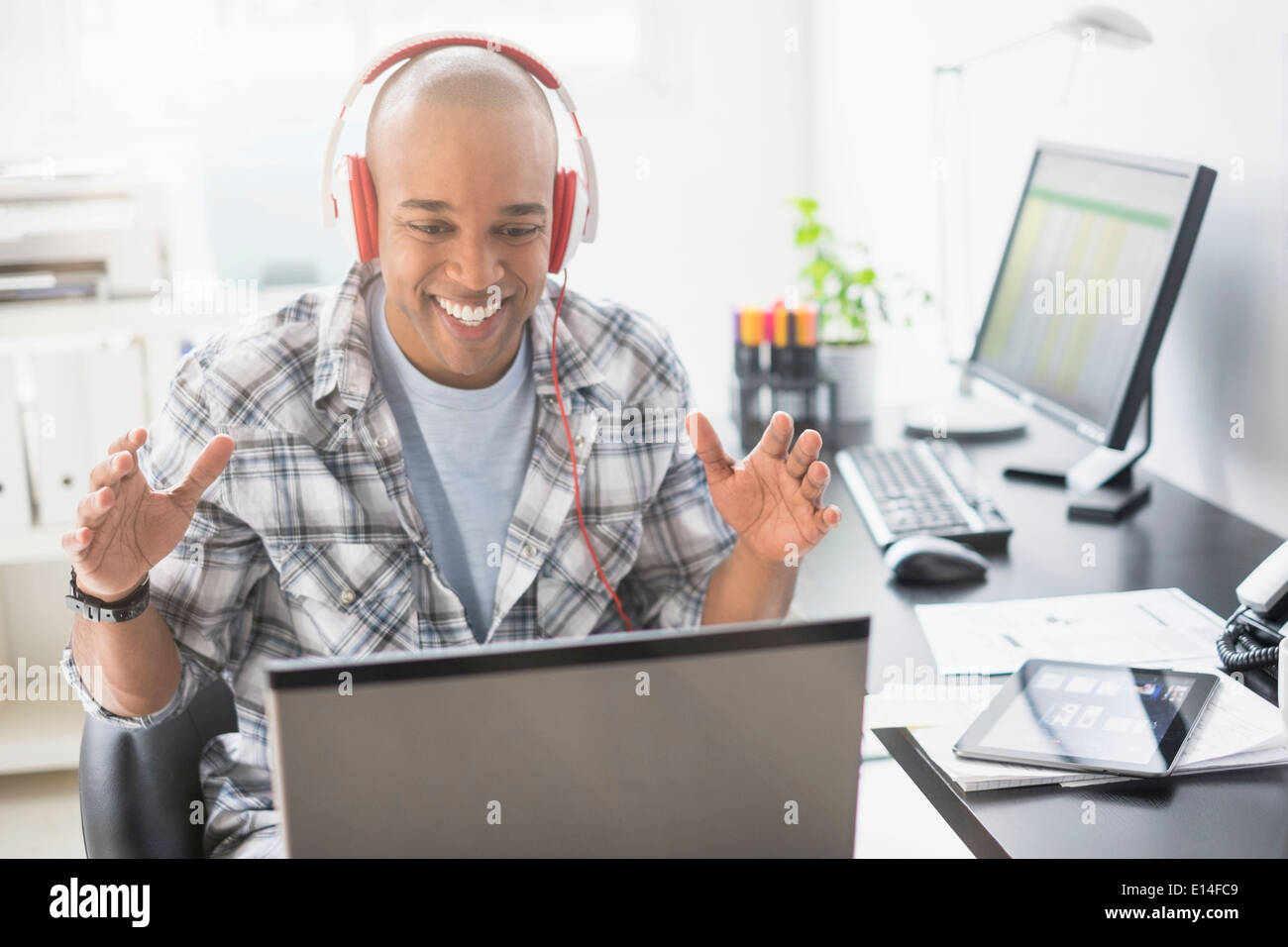 Black businessman listening to headphones in office Stock Photo