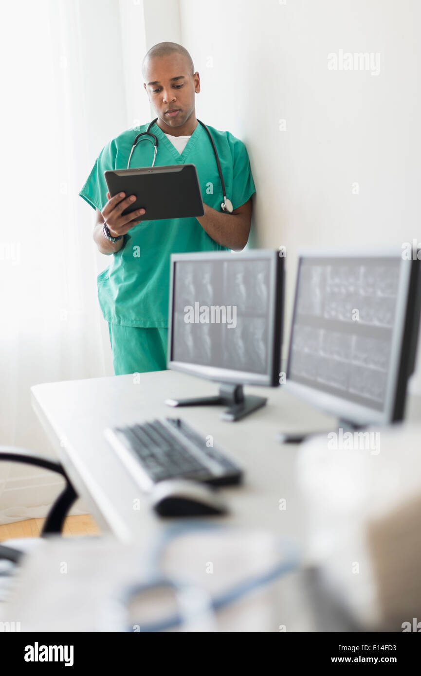 Black doctor using digital tablet in office Stock Photo