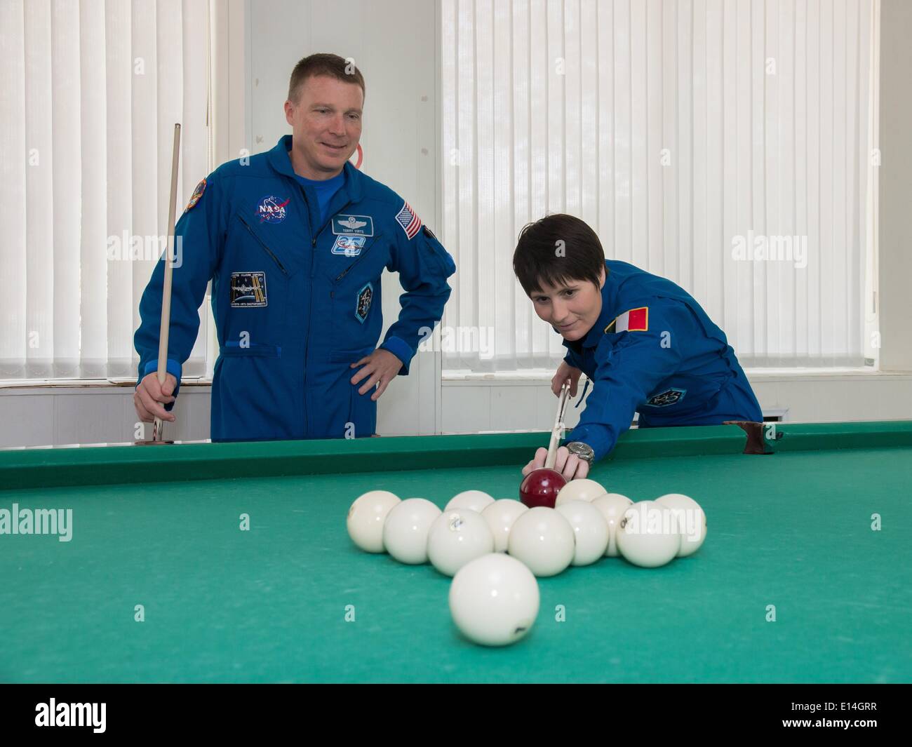 ISS Expedition 41 backup crewmembers Terry Virts of NASA, left, and Samantha Cristoforetti of the European Space Agency try their hand at a game of billiards at the Cosmonaut Hotel May 21, 2014 in Baikonur, Kazakhstan. Expedition 41 will launch on May 29 in the Soyuz TMA-13M spacecraft from Baikonur for a 5 ½ month mission on the International Space Station. Stock Photo