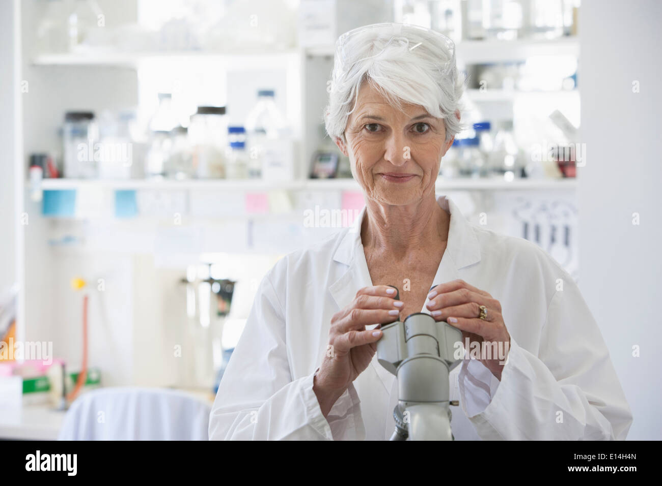 Senior Caucasian scientist using microscope in lab Stock Photo