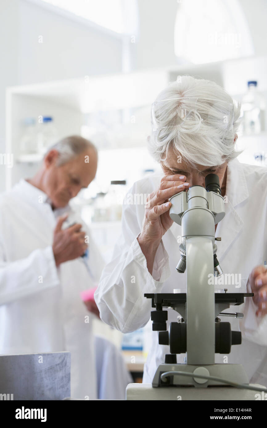 Senior Caucasian scientist using microscope in lab Stock Photo