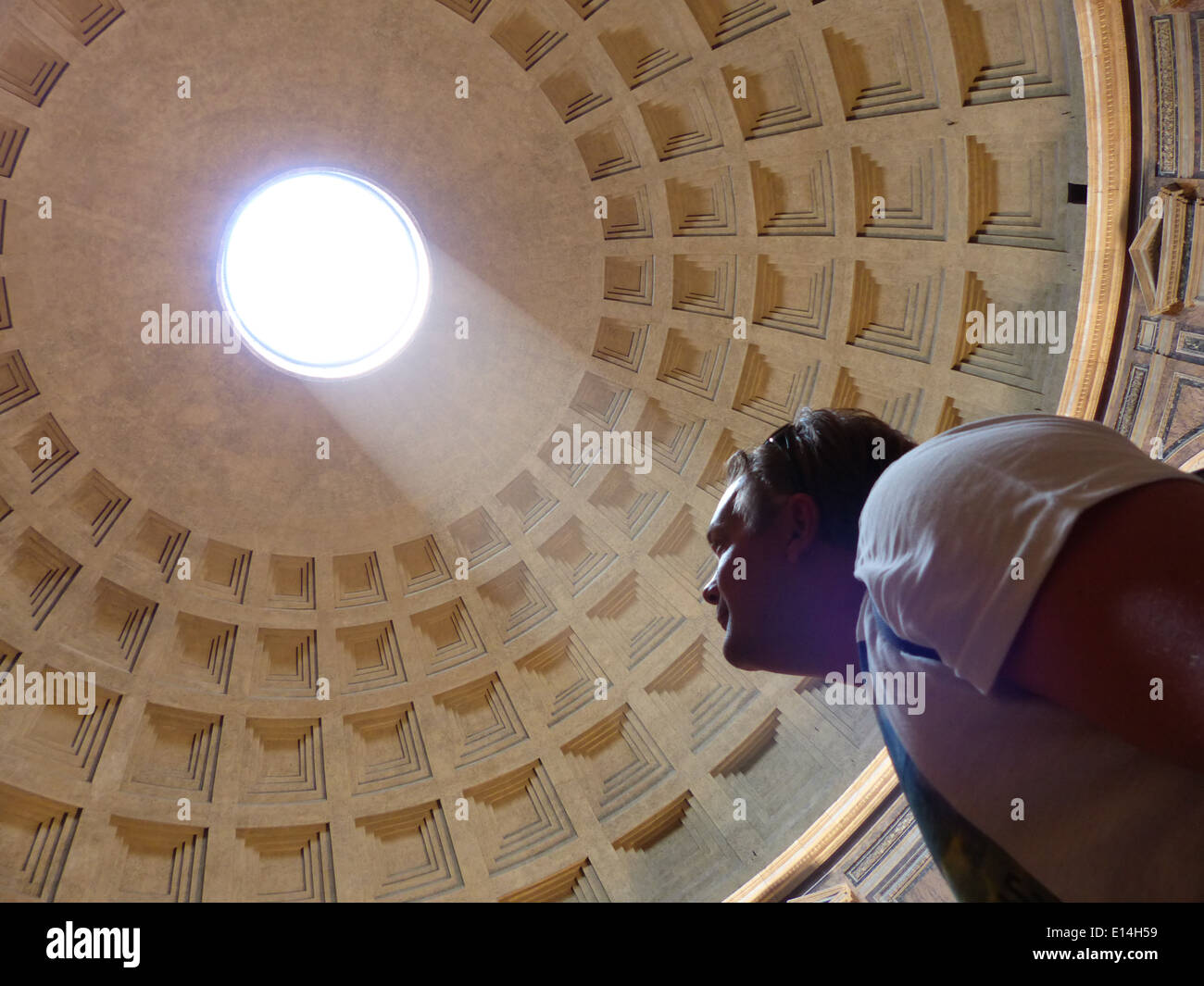 Man Looking Up At Hole In Ceiling Of Pantheon In Rome With