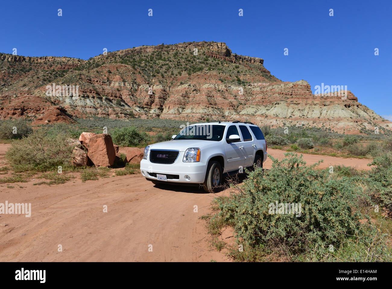 A white GMC Yukon in and around the Rock formations of Utah. Stock Photo