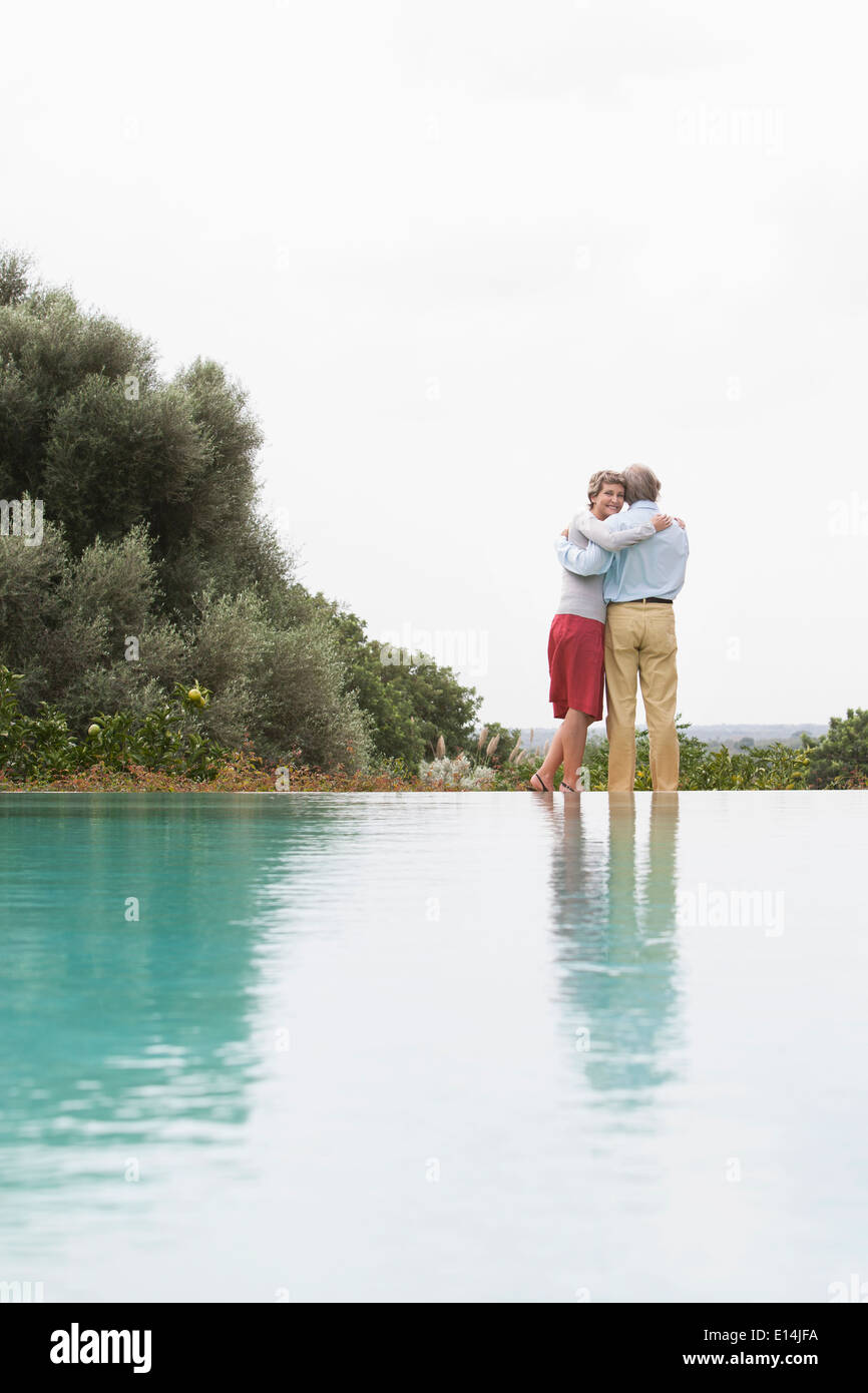 Couple standing by infinity pool Stock Photo