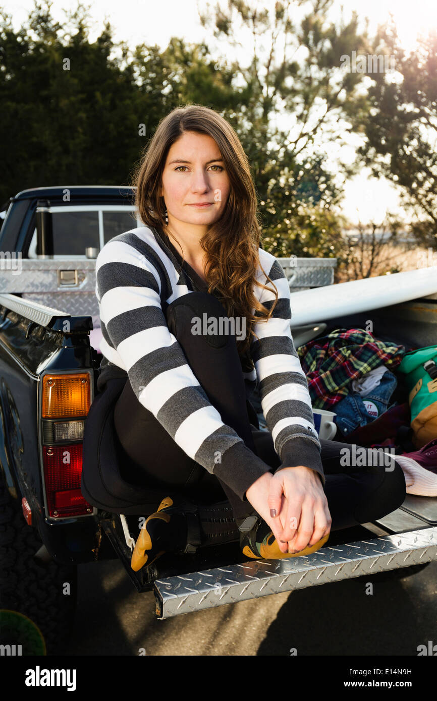 Woman sitting in truck bed Stock Photo
