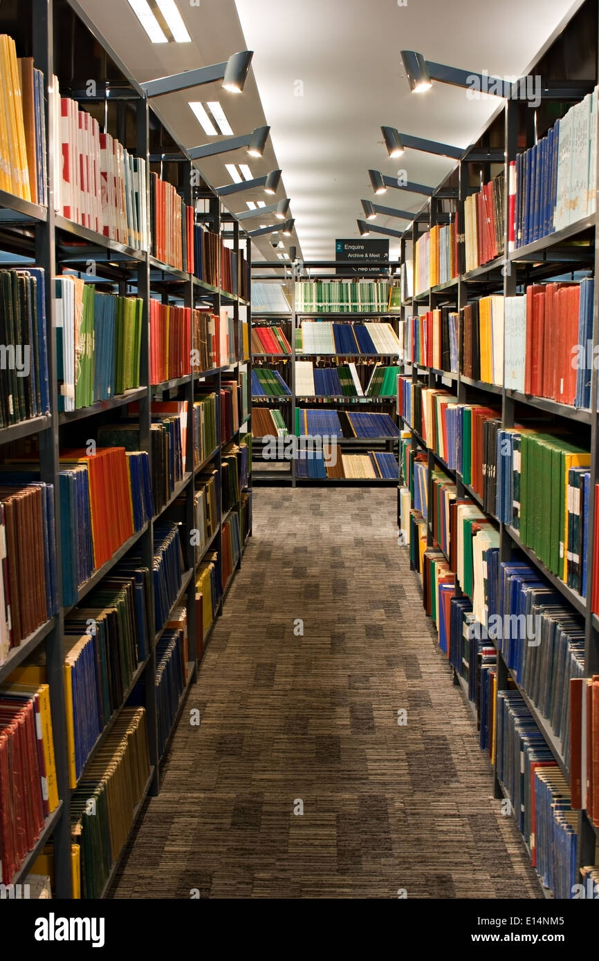 Library books stacked on shelving in modern library Stock Photo Alamy