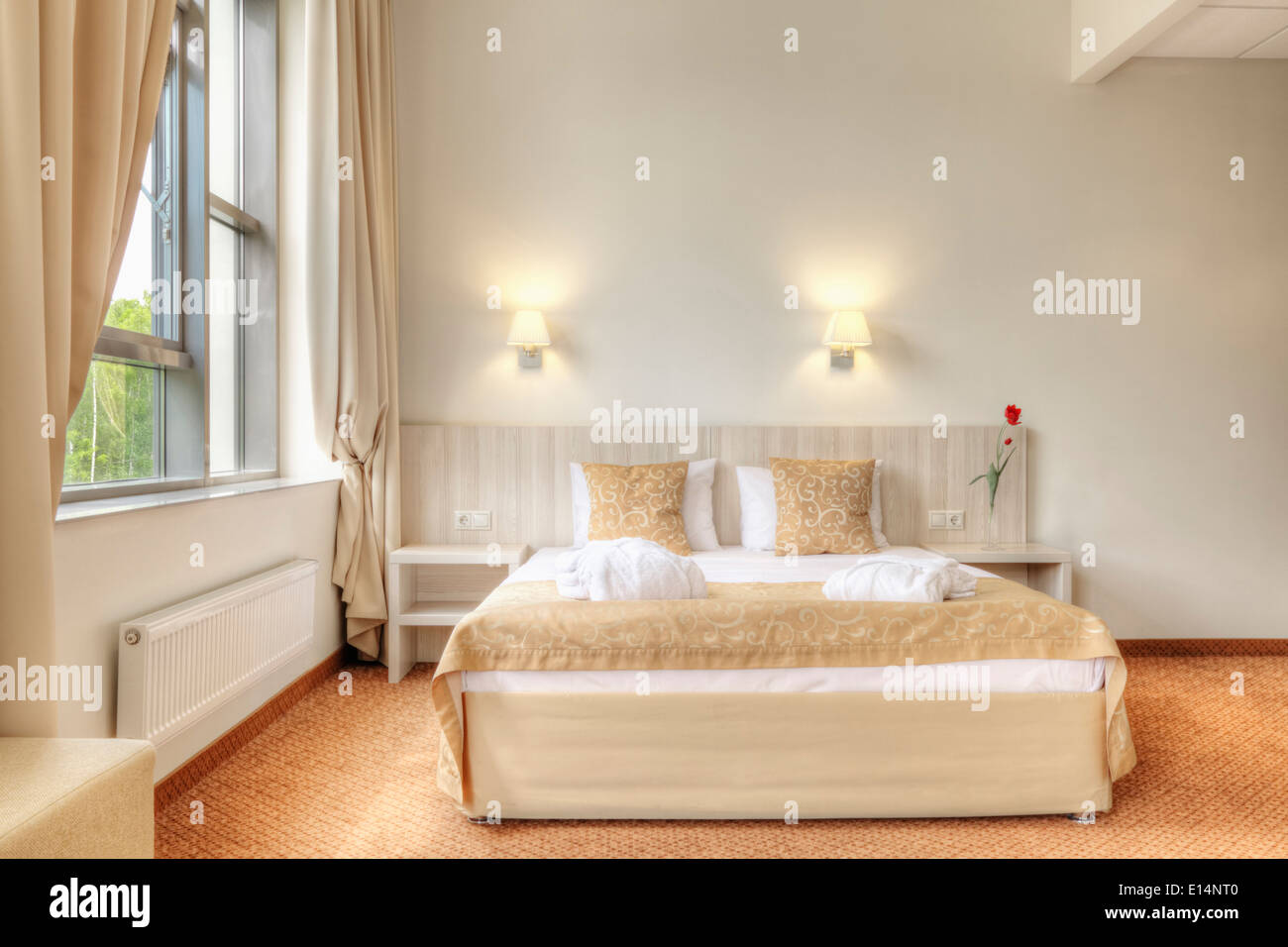 Bed and curtains in hotel room Stock Photo