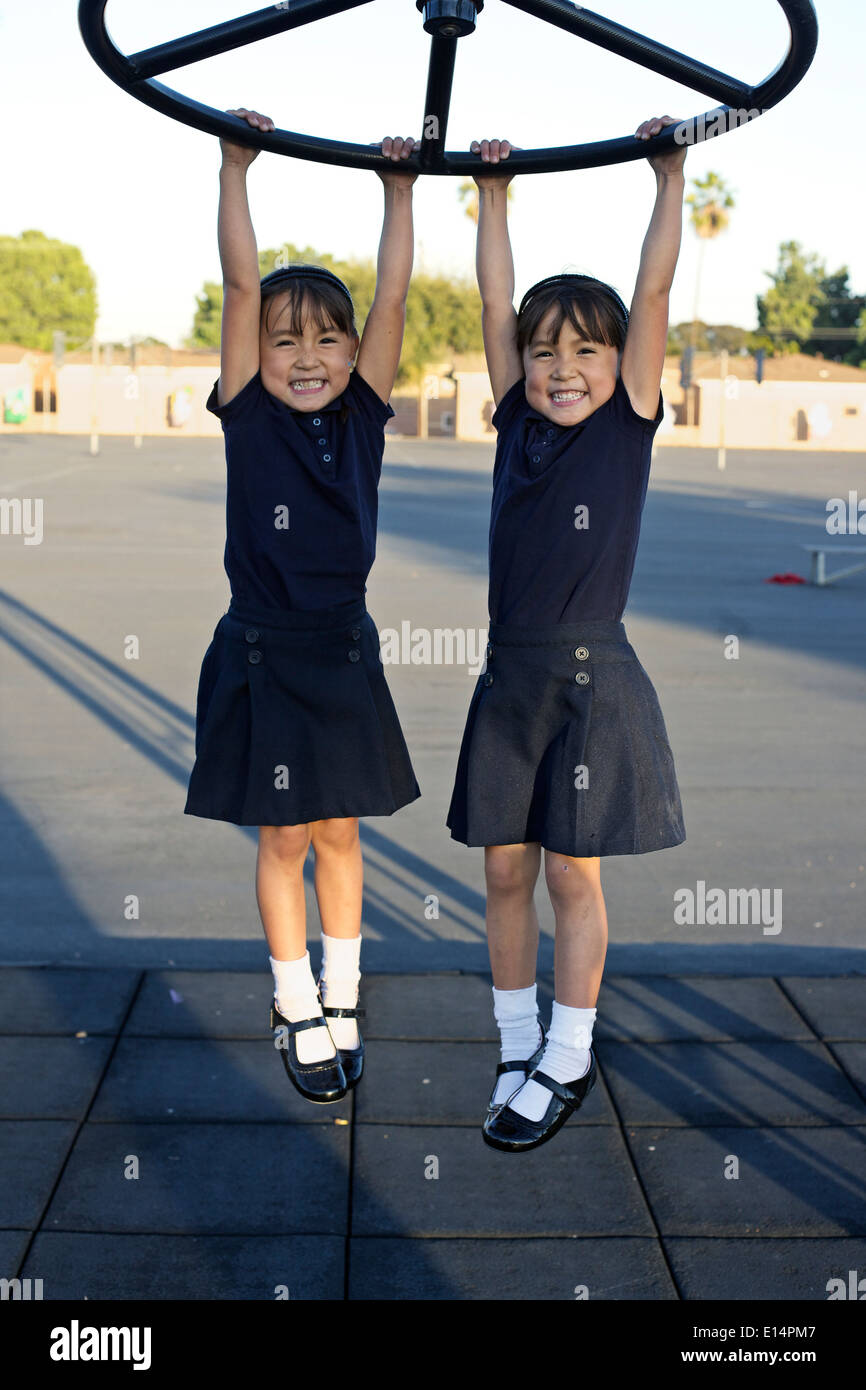 Twin girls playing on playground Stock Photo