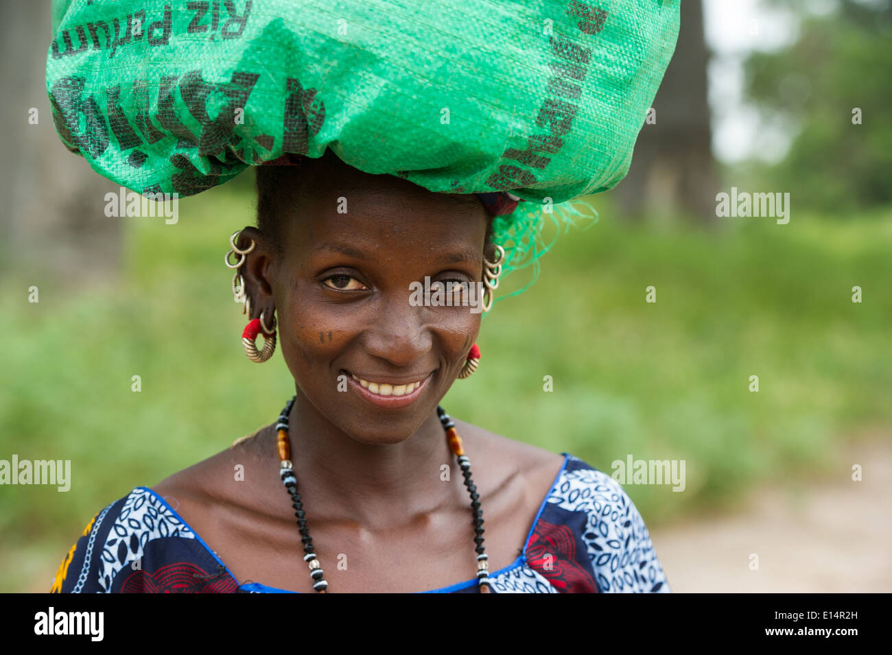 Fula woman carrying a bag to the market, the Gambia Stock Photo