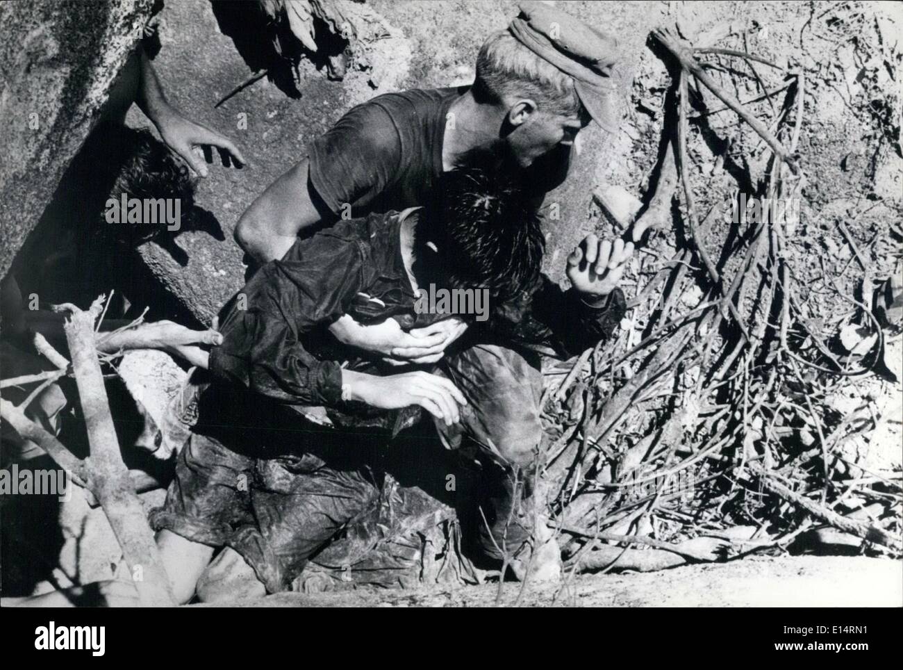 Apr. 18, 2012 - Wounded Foe Helped: A U.S. Marine carries a wounded North Vietnamese soldier out of a cave complex after a brief fire fight in the Que Son Mountains. Three men in the cave surrendered, another North Vietnamese soldier is seen following the wounded man. Stock Photo