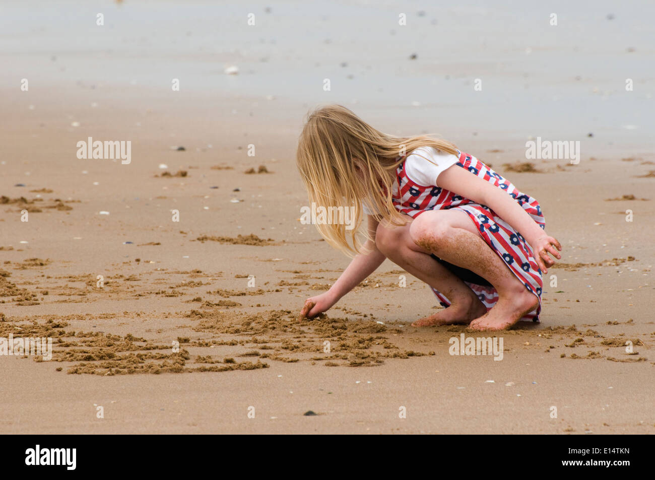 young girl writing in the sand Stock Photo