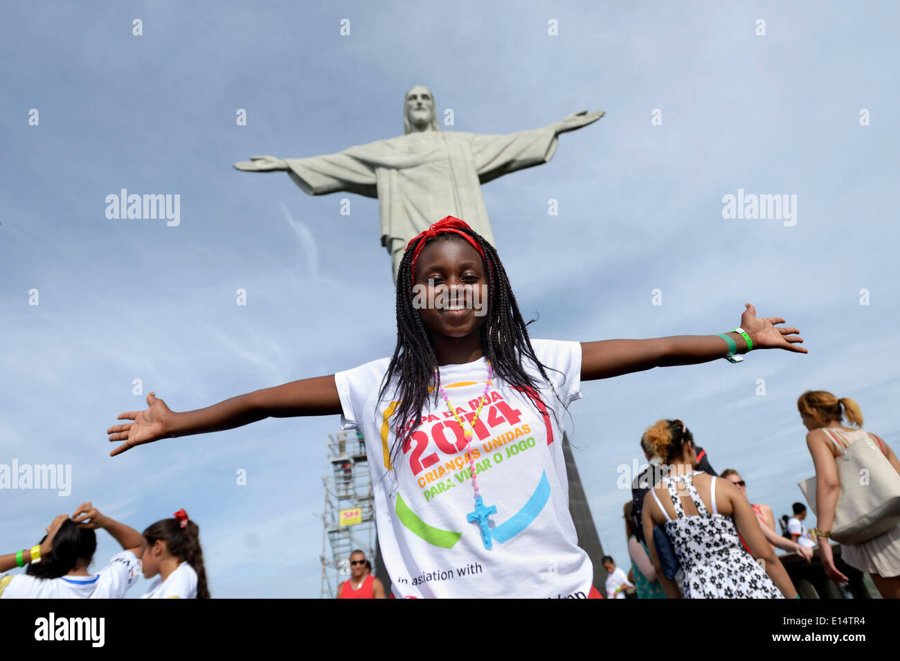Young woman from Mozambique with her arms outstretched in front of the Christ the Redeemer statue, Cristo Redentor Stock Photo