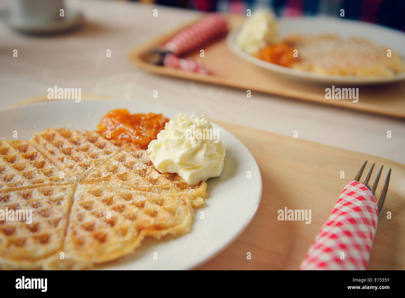 Heartshaped waffle with whipped cream and cloudberry jam Stock Photo