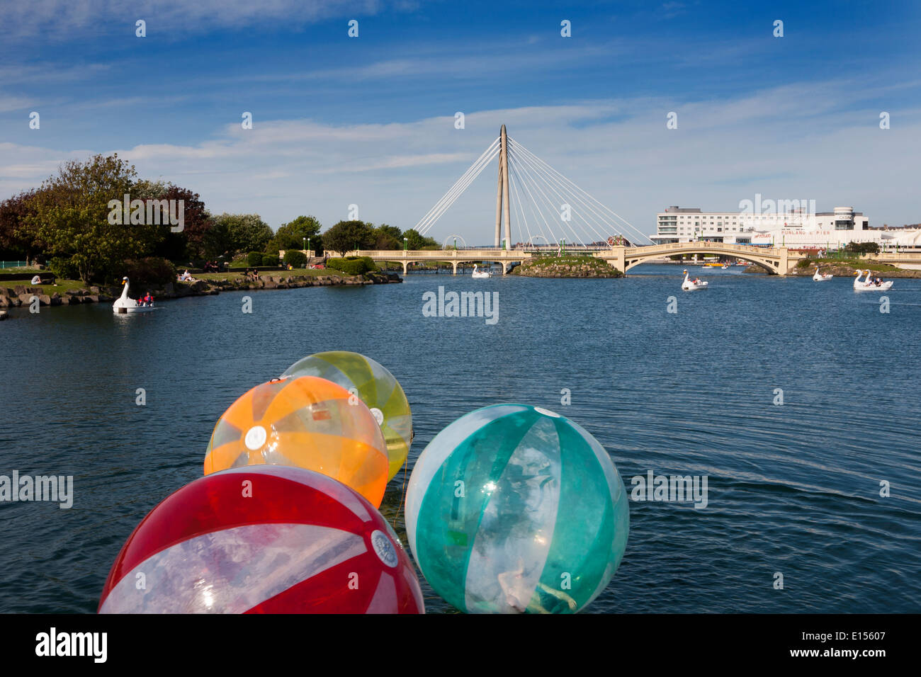 Marine lake bridge southport with children playing in bubble balls in the water, southport england merseyside Stock Photo