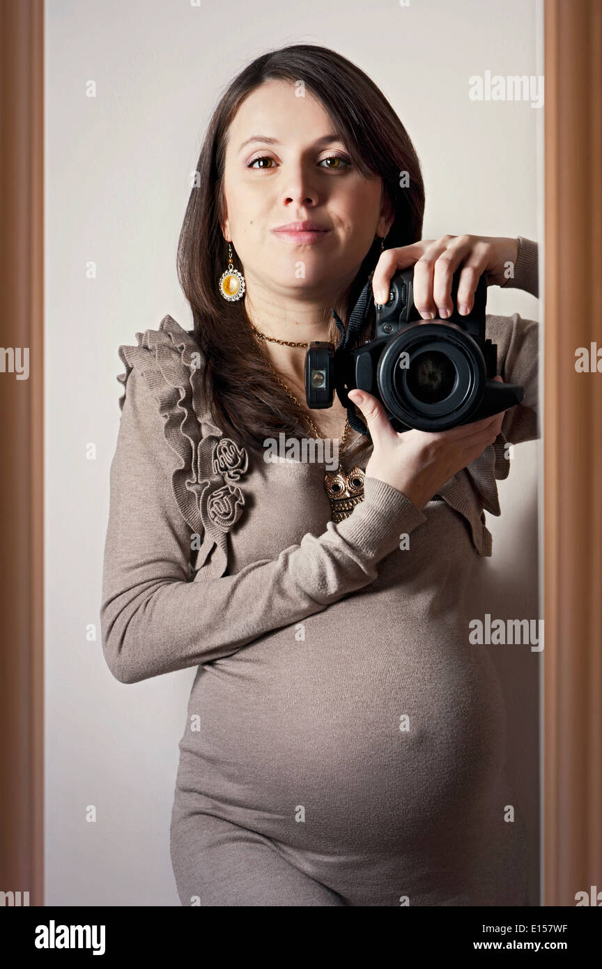 Beautiful pregnant woman taking self-portrait with DSLR camera Stock Photo  - Alamy