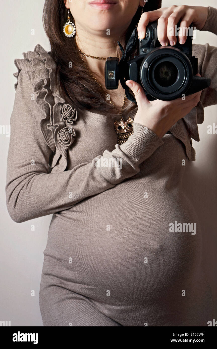 Image of pregnant woman taking self-portrait with DSLR camera Stock Photo
