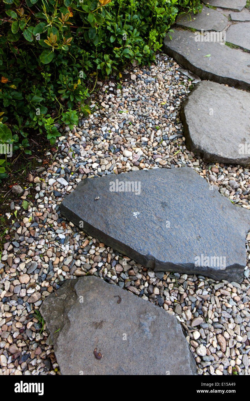 Stepping stone path and gravel in garden border, stones Stock Photo