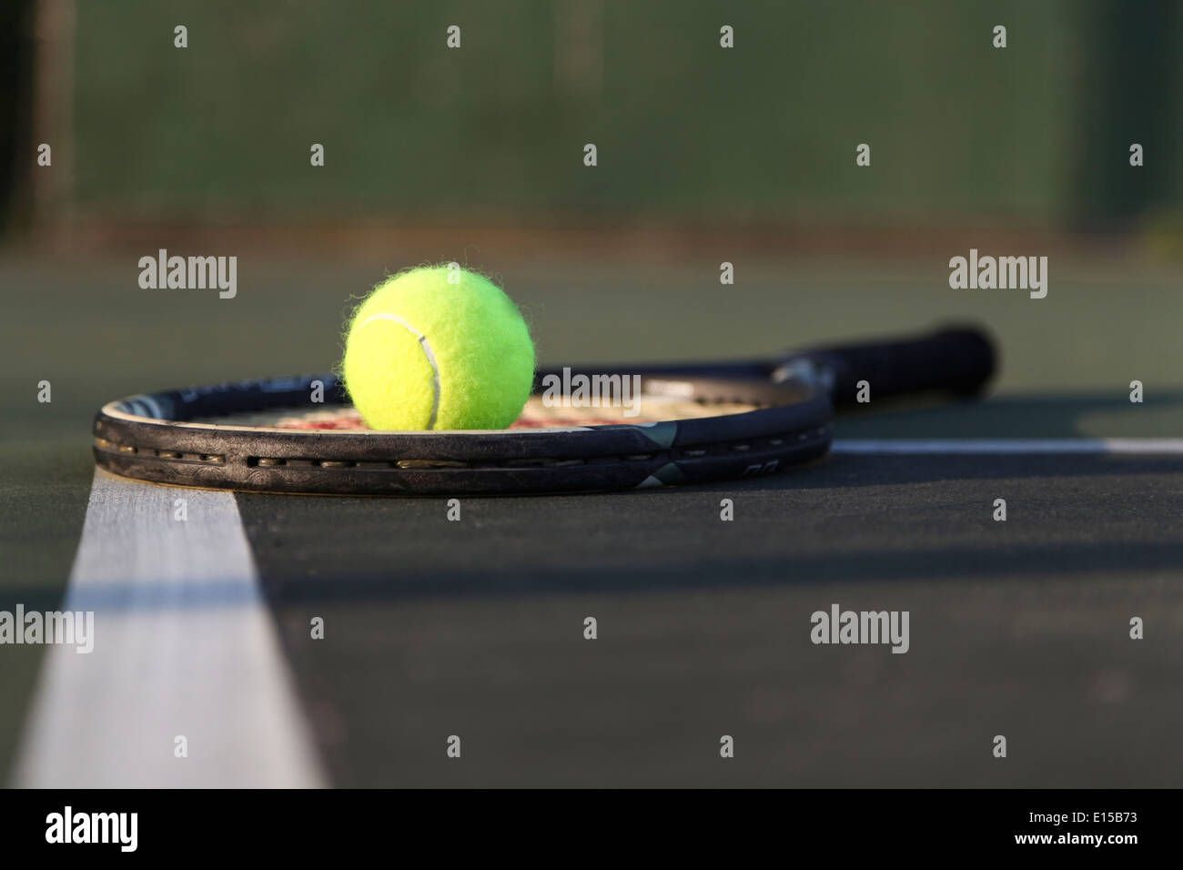 Tennis racket, ball laying on court. Stock Photo
