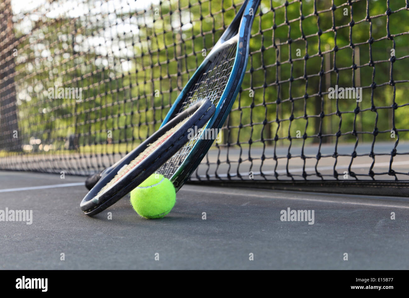 Tennis rackets, ball leaning against net. Stock Photo