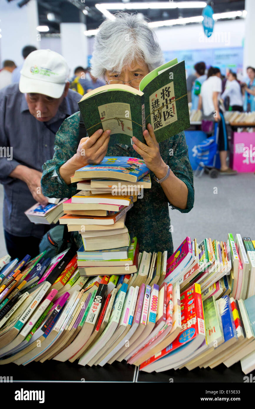 Beijing, China. 23rd May, 2014. Readers attend the fourth Beijing Book Exchange Fair held at the Capital Library of China in Beijing, capital of China, May 23, 2014. The fourth Beijing Book Exchange Fair opened Friday in Beijing. Over 10,000 used books and magazines are available for swaps. © Zhao Bing/Xinhua/Alamy Live News Stock Photo