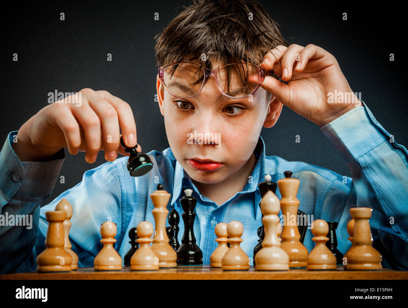Wunderkind play chess. Funny Nerd boy. Stock Photo