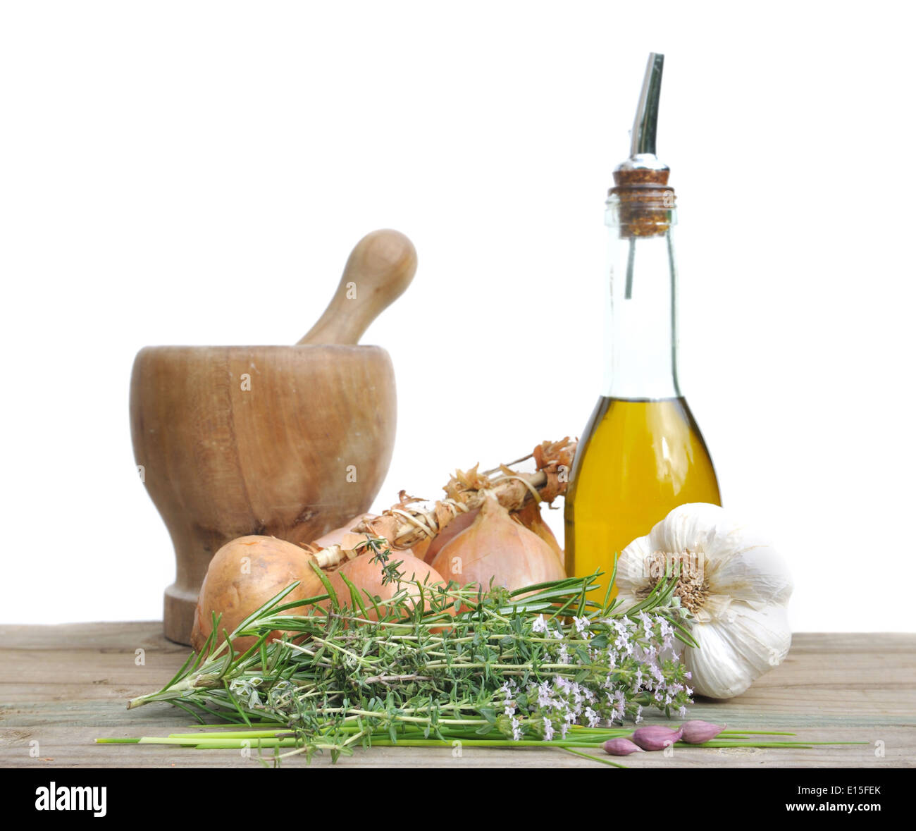 herbal, onions, garlic, oil and pestle on a plank on white background Stock Photo