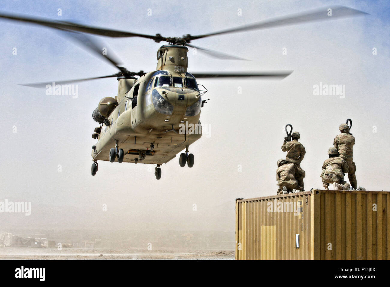 A US Army CH-47 Chinook helicopter load team prepares to hook up a container to be airlifted June 18, 2013 in Uruzgan province, Afghanistan. The equipment is being moved to Kandahar Airfield as FOB Hadrian shuts down. Stock Photo