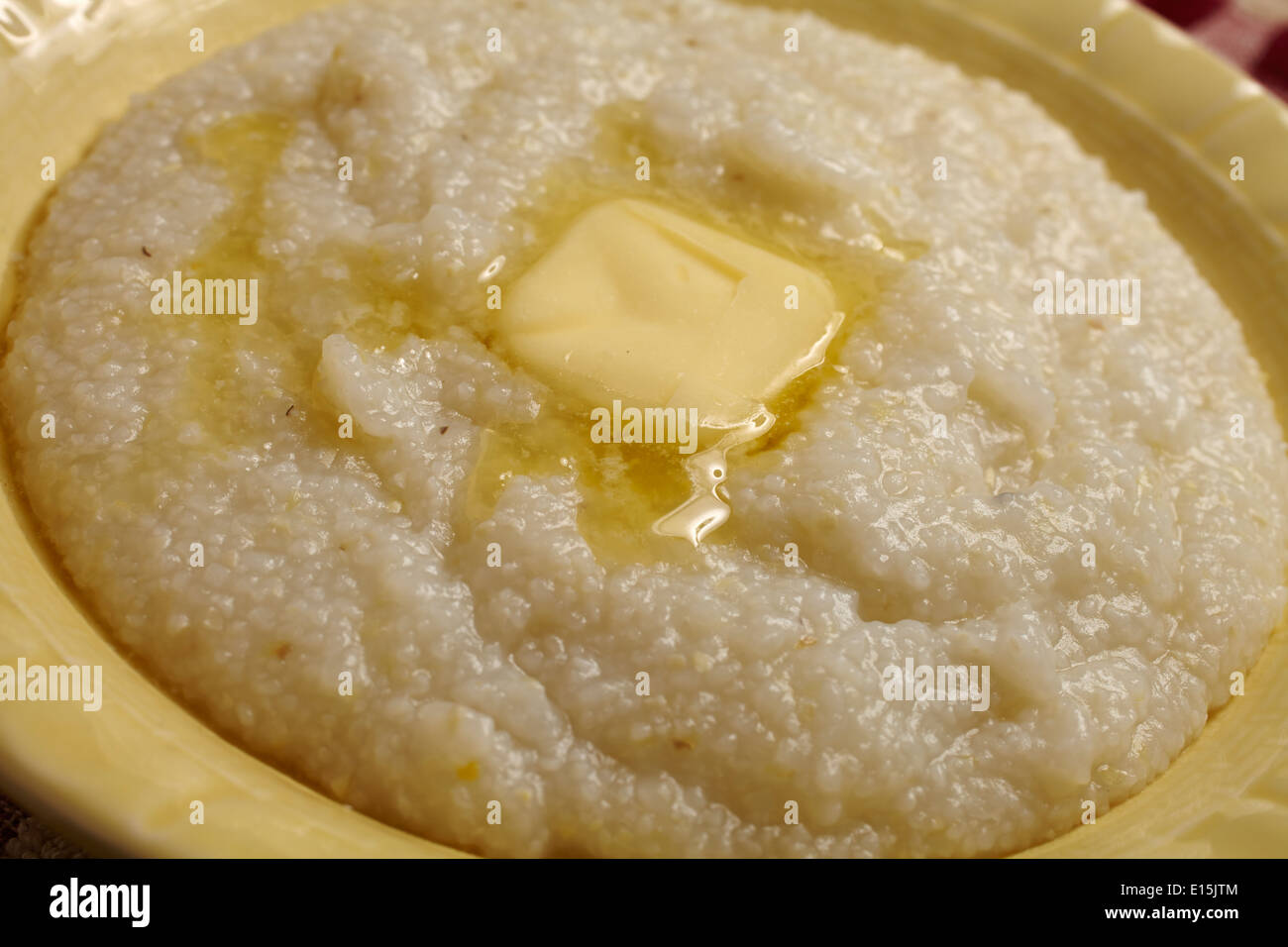 Bowl of hominy grits with a pat of butter Stock Photo