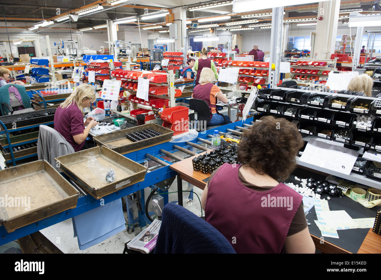 Assembly workers on a factory shop-floor assembling electrical switchgear. No faces can be seen. Stock Photo