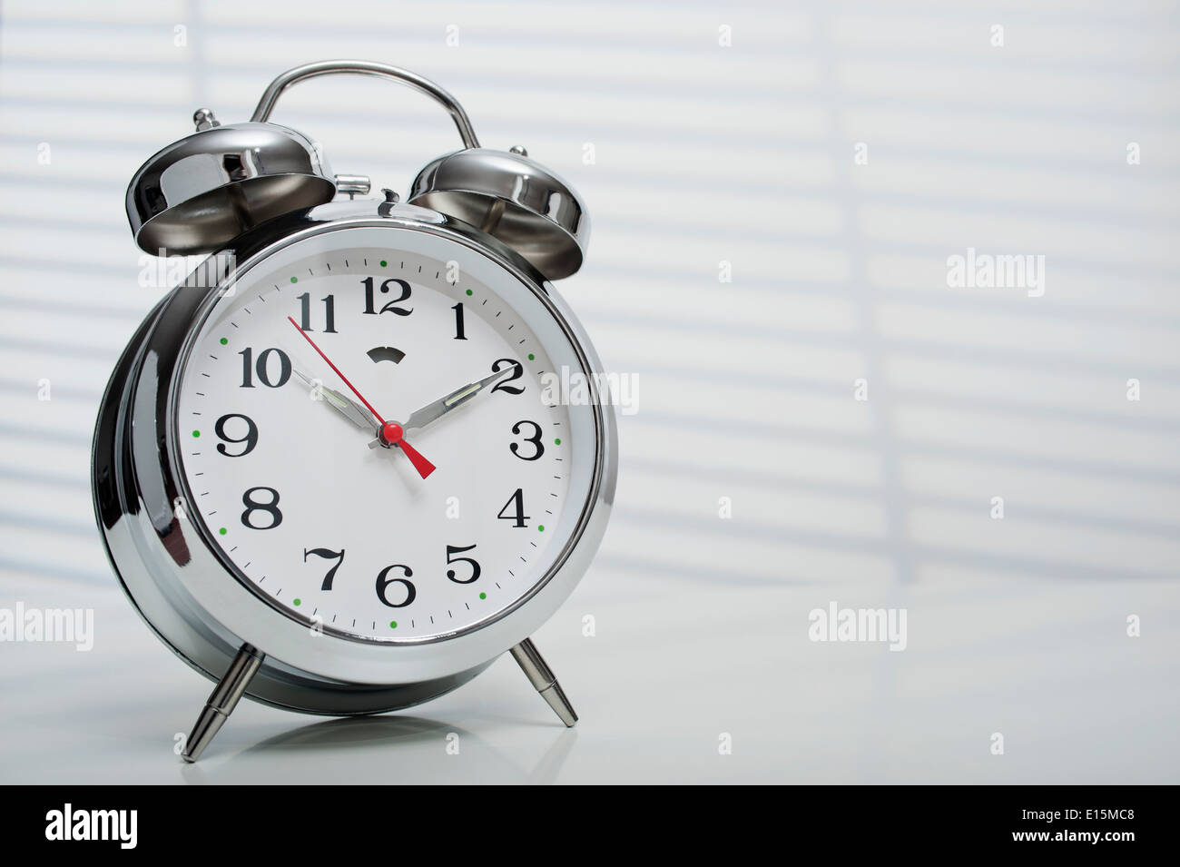classical alarm clock on white background with sunlight Stock Photo